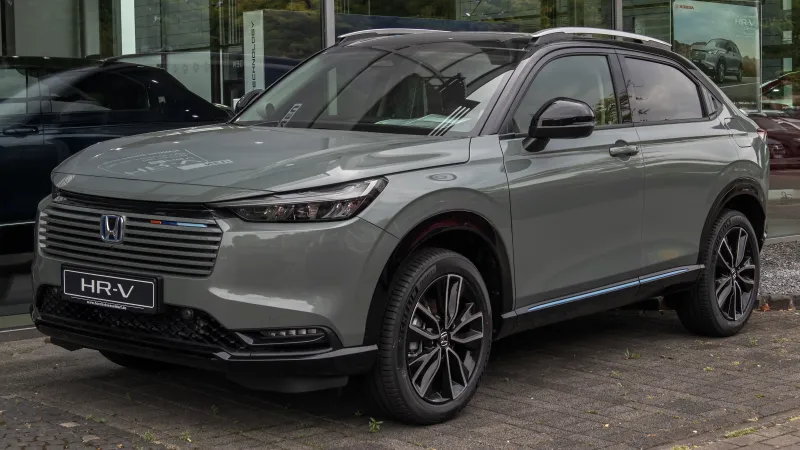 Honda HR-V e:HEV renovado, gris verdoso con el techo negro, visto de tres cuartos delantero