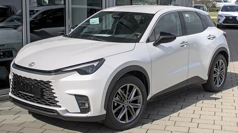 Lexus LBX blanco, visto de tres cuartos delantero frente a un concesionario de Filderstadt (Alemania)
