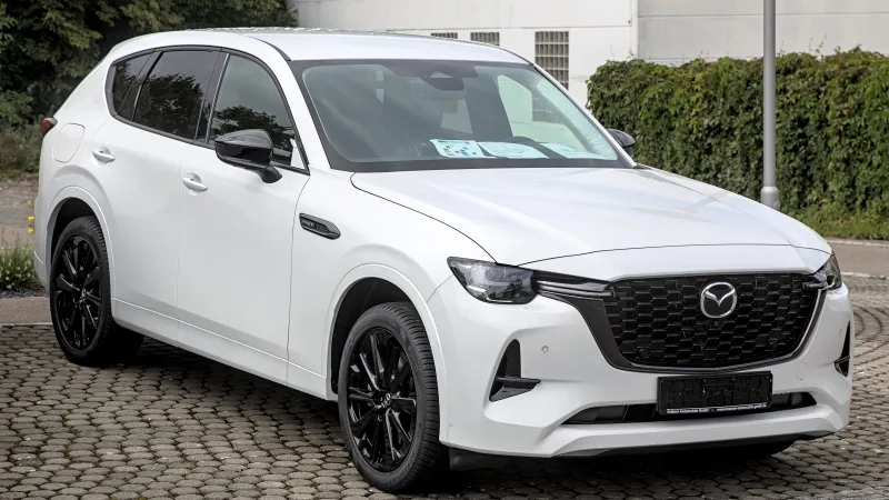 Mazda CX-60 híbrido enchufable blanco con llantas negras, aparcado y visto de tres cuartos delantero