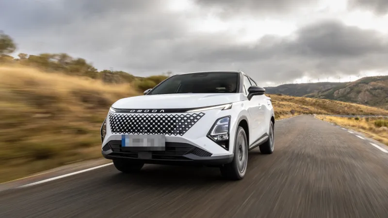 Omoda 5 SHS híbrido blanco circulando por una carretera de montaña, visto de tres cuartos delantero